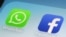 FILE - This Feb. 19, 2014, file photo, shows WhatsApp and Facebook app icons on a smartphone in New York. Global messaging service WhatsApp says it will start sharing the phone numbers of its users with Facebook, its parent company.
