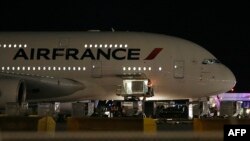 FILE - Workers load cargo on an Air France Airbus 380 at Salt Lake City International Airport, Nov. 17, 2015.