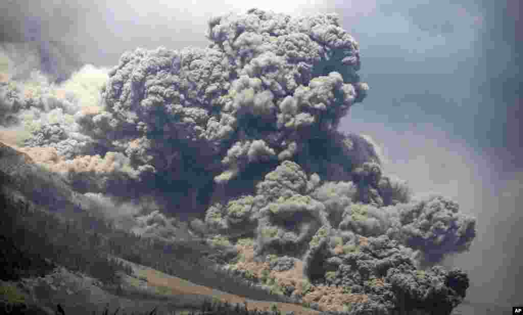 Mount Sinabung releases pyroclastic flows during an eruption as seen from Payung village, North Sumatra, Indonesia. The rumbling volcano unleashed fresh clouds of searing gas, killing more than a dozen of people.