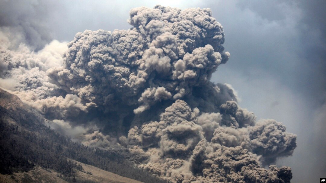 Gunung Sinabung melepaskan uap panas, terlihat dari desa Payung, Sumatera Utara (3/2). (AP/Binsar Bakkara)