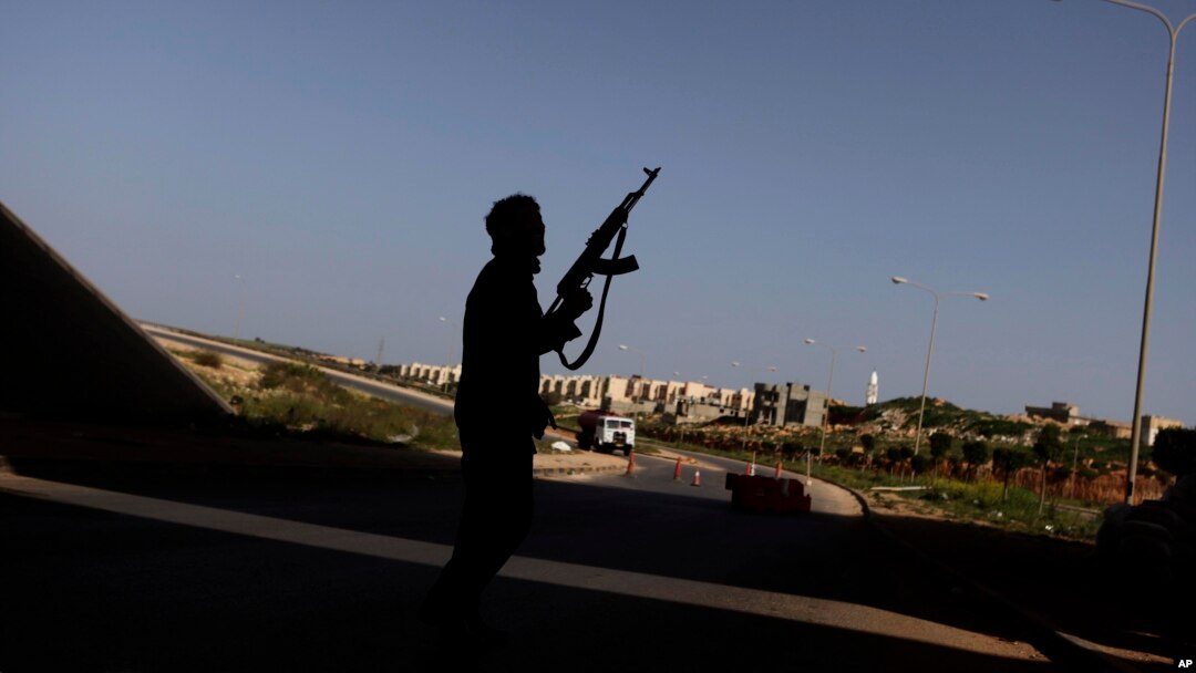 FILE - A Libyan rebel mans a check point on the outskirts of Benghazi, Libya, March 30, 2011. Fighting was continuing Saturday for control of the country's oil facilities around the city.