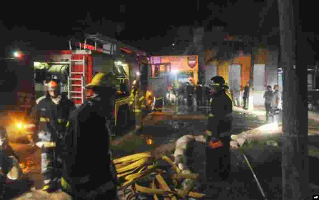Firefighters stand outside of the prison in Comayagua, Honduras, early February 15, 2012, after a lethal fire swept through the jail. (AP)