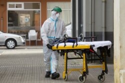 A health team member enters a home in A Marina, near Lugo, northwest Spain, July 5, 2020. Authorities in northwestern Spain have ordered the lockdown of a county with a population over 70,000 for fears of a coronavirus outbreak.