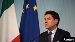 FILE - Italian Prime Minister Giuseppe Conte reacts to Italy's ruling coalition breakdown, speaking to journalists at an impromptu, late evening news conference in Rome, Aug. 8, 2019.