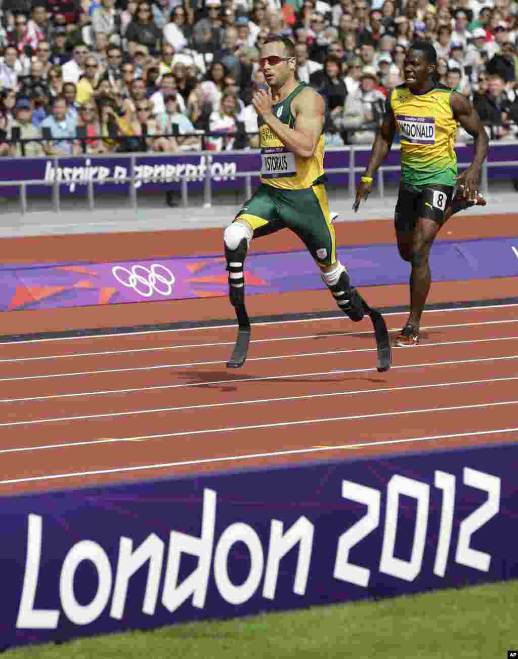 Muafrika Kusini Oscar Pistorius, kushoto, na Mjamaica Rusheen McDonald wakimaliza mchugo wa mbio za mita&nbsp; 400 wakati wa micehzo ya riadha kwenye uwanja wa&nbsp; Olympic Stadium, London, August 4, 2012.