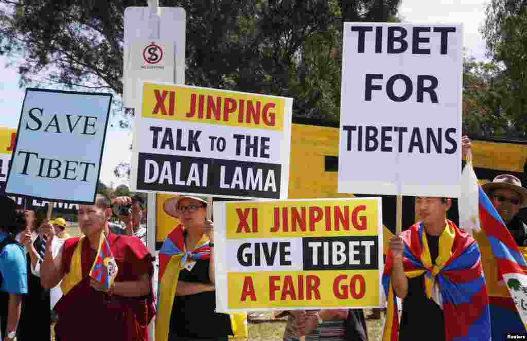 Para demonstran yang memprotes Presiden China Xi Jinping di luar Parlemen Australia, Canberra (17/11). (Reuters/David Gray)