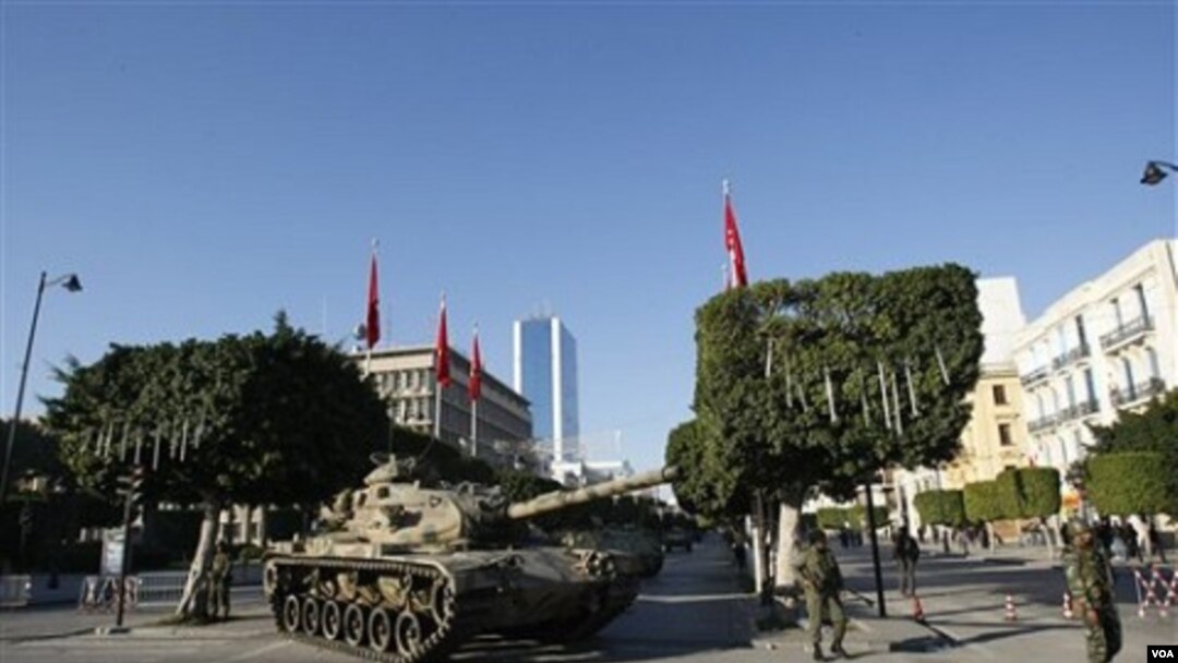 Sebuah tank dan sejumlah tentara melakukan patroli di pusat ibukota Tunis, 16 Januari 2011.