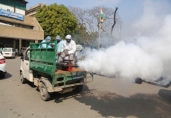 Indian municipal workers spray disinfectants as a precautionary measure against COVID-19 outside Government Medical College hospital in Jammu, India, March 19, 2020.