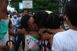 A man is hugged by two women after being released from Insein Prison in Yangon, Myanmar, June 30, 2021. Myanmar's government released about 2,300 prisoners.
