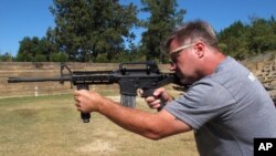 Shooting instructor Frankie McRae aims an AR-15 rifle fitted with a "bump stock" at his 37 PSR Gun Club in Bunnlevel, North Carolina, Oct. 4, 2017. 