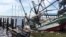 A shrimp boat is sunk at its mooring along the Pascagoula River in Moss Point, Mississippi, Oct. 8, 2017, after Hurricane Nate made landfall on Mississippi's Gulf Coast.