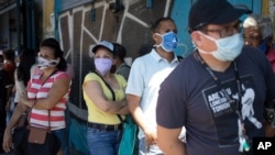 Clientes hacen cola frente a un supermercado en Caracas, Venezuela. Marzo 16 de 2020.