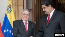FILE - Cuba's Raul Castro, left, shakes hands with Venezuela's Nicolas Maduro in Caracas, Venezuela, March 5, 2018.