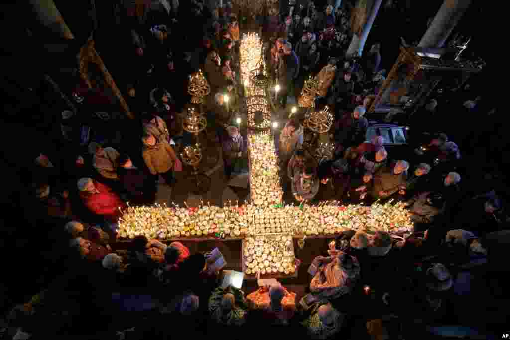 Worshippers gather around a cross during Mass for the &#39;sanctification of honey&#39; at the Presentation of the Blessed Virgin church in the town of Blagoevgrad, some 100 km (62 miles) south of the Bulgarian capital of Sofia.