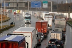 FILE - Trucks queue on the A16 highway to enter the Channel tunnel in Calais, northern France, Dec. 17, 2020.