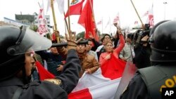 Polisi berupaya menghentikan aksi demo menentang pemerintah Presiden Ollanta Humala Peru dan anggota parlemen, di Lima, Peru (27/7).