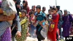 Iraqi families are pictured near al-Sejar village, in Iraq's Anbar province, after fleeing the city of Fallujah, on May 27, 2016, during a major operation by Iraqi forces to retake the city of Fallujah from the Islamic State (IS) group.