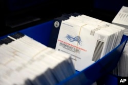 FILE - Mail-in ballots for the 2020 election are seen after being sorted at the Chester County Voter Services Office in West Chester, Pa.