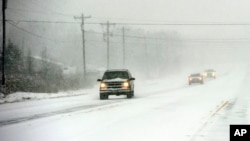 Drivers navigate U.S. Hwy 25 in southern Greenville County, as snow falls near Greenville, S.C., Feb. 12, 2014.