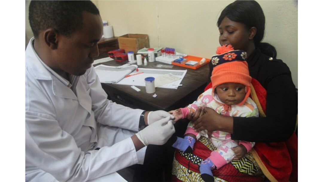 FILE - A doctor tests a child for malaria at the Ithani-Asheri Hospital in Arusha, Tanzania, May 11, 2016.