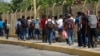 FILE - Central American migrants cross into Mexico from Guatemala, near Ciudad Hidalgo, Mexico, June 4, 2019. The migrants walked over the bridge and waited to register at a Mexican immigration office.