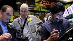 Traders work in the crude oil and natural gas options pit at the New York Mercantile Exchange in New York, (File June 29, 2011).