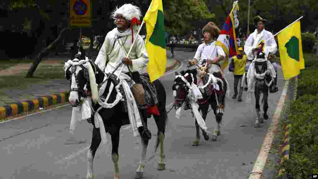 Exiled Tibetan activists in their traditional dress ride on horses during a protest march to mark the 55th anniversary of the failed uprising in the Tibetan capital Lhasa in 1959, in New Delhi, India, Monday, March 10, 2014. (AP Photo/Manish Swarup