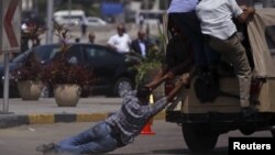 Members of 'Field Marshal Hussein Tantawi' group comprised of official and police guards, try to ride a military police vehicle after a funeral for soldiers who were killed during an attack at a checkpoint along the Sinai border with Israel 