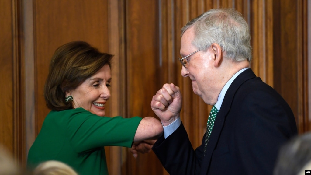 House Speaker Nancy Pelosi of Calif., left, and Senate Majority Leader Mitch McConnell of Ky., right, bump elbows as they attend a lunch with Irish Prime Minister Leo Varadkar on Capitol Hill in Washington, Thursday, March 12, 2020. (AP Photo/Susan Walsh)