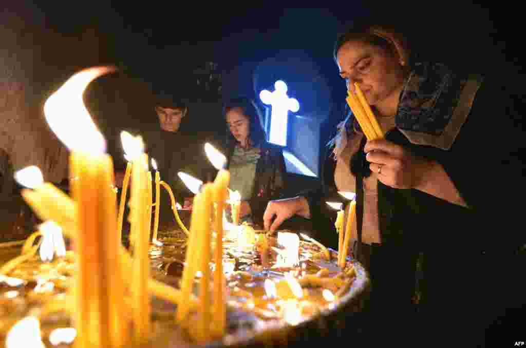 Los fieles cristianos armenios encienden velas durante un servicio religioso de Pascua en Erev&#225;n el 4 de abril de 2021.