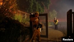 A firefighter hoses a hot spot while battling the Kincade Fire in Geyserville, Calif., Oct. 24, 2019. 