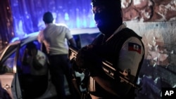 A police officer stands at an intersection in Port-au-Prince, Haiti, late Wednesday, July 14, 2021. Haiti is in the midst of a heightened security situation after the July 7 assassination of President Jovenel Moise. (AP Photo/Matias Delacroix)