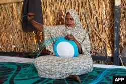 FILE—23-year-old Sudanese refugee and student Asha Mohamat Mousa weaves a dish with plastic threads inside her shelter in the Tongori refugee camp, on April 11, 2024.