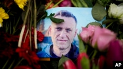 (FILE) Rain drops cover a portrait of Russian opposition leader Alexei Navalny in front of the Russian embassy in Berlin.