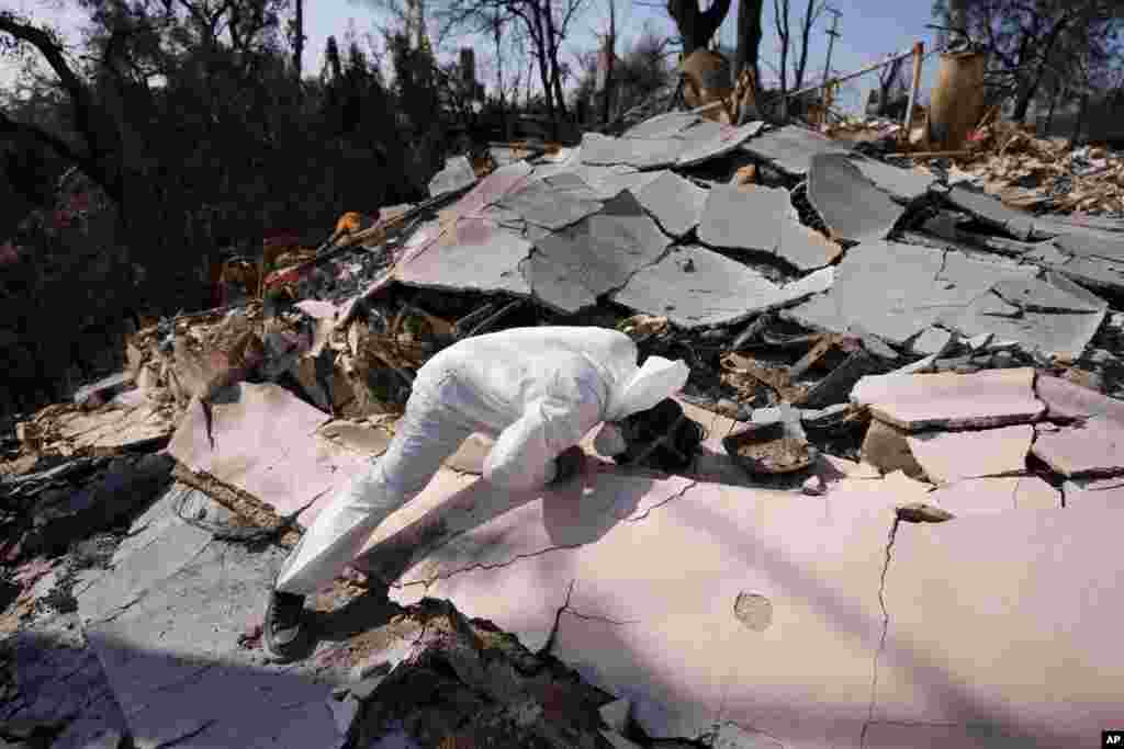 John Borbone searches through his fire-ravaged property after the Palisades Fire in the Pacific Palisades neighborhood of Los Angeles.