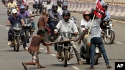 Activists of a trade union group stop motorcyclists to keep vehicles off the road during a daylong nationwide strike in the eastern Indian city Bhubaneswar, India, Wednesday, Sept. 2, 2015.