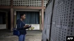 Un observateur en train de regarder la liste des électeurs à l'intérieur d'un bureau de vote, le 29 décembre 2018, à Kinshasa.