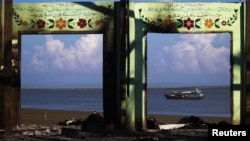 A boat is framed by the ruins of a destroyed mosque in a part of Pauktaw township that was burned in recent violence in Rakhine state, Burma, October 27, 2012.