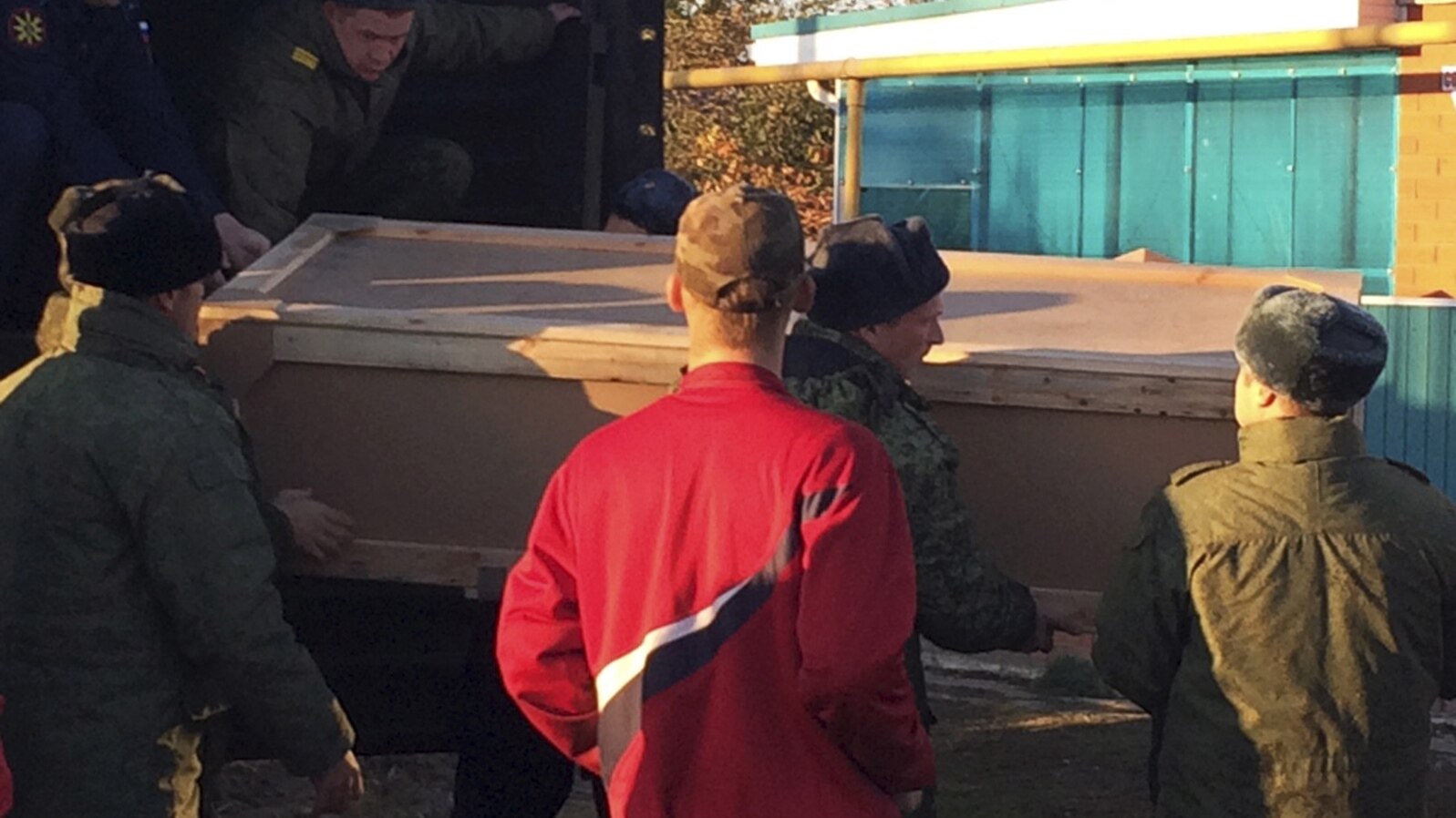 FILE - Russian servicemen unload a coffin containing the body of Vadim Kostenko, a member of the Russian air force's support staff in Syria, from a truck near his family's house in Grechanaya Balka, Russia, Oct. 27, 2015.