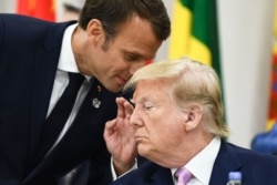 FILE - French President Emmanuel Macron speaks with US President Donald Trump at the G-20 Summit in Osaka, June 28, 2019. On Friday, Trump Macron of "foolishness" over a move to tax global tech giants, promising substantial retaliation.