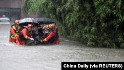 中国安徽救援人员在大雨中疏散合肥居民。（2021年7月8日）