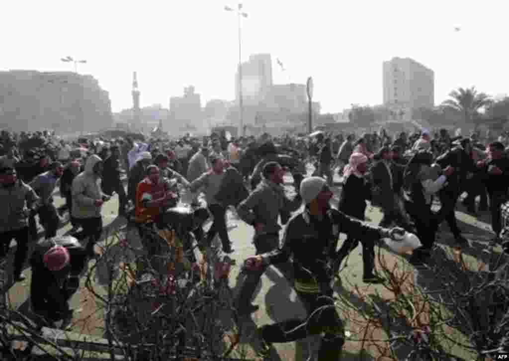Supporters of President Hosni Mubarak fight with anti-Mubarak protesters in Cairo, Egypt, Wednesday, Feb.2, 2011. Several thousand supporters of Mubarak, including some riding horses and camels and wielding whips, clashed with anti-government protesters 