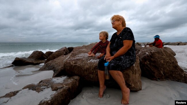 Una señora y su nieto miran el clima nublado en la plata de Saint Pete, en Florida, el domingo 4 de agosto.