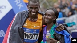 Kenya's Stanley Biwott (L) embraces fellow Kenyan Mary Keitany after the pair won the men's and women's professional athlete divisions in the the New York City marathon, Nov. 1, 2015, in New York.