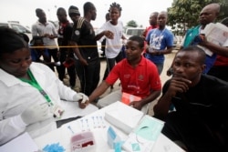 FILE - A doctor takes an AIDS/HIV blood test from an athlete during the 18th National Sports Festival in Lagos, Nigeria.