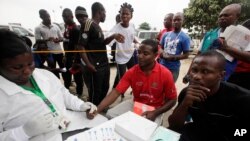 Seorang dokter tampak mengambil sampel darah dari atlet sebagai bagian dari tes HIV/AIDS dalam Festival Olahraga di Lagos, Nigeria, pada 1 Desember 2012. (Foto: AP/Sunday Alamba)