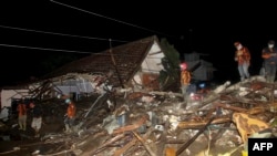 Tim penyelamat mencari korban selamat di tengah puing-puing pasca banjir bandang yang sejauh ini dilaporkan 11 orang hilang, di Malang, Jawa Timur pada 4 November 2021. (Foto: AFP)