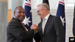 Perdana Menteri Australia Anthony Albanese, kanan, menyambut Perdana Menteri Papua Nugini James Marape, kiri, di Gedung Parlemen di Canberra, Australia, Kamis, 8 Februari 2024. (Mick Tsikas/AAP Image via AP)