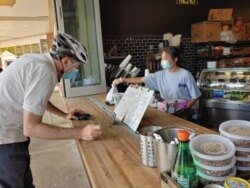 A customer stops by the Bread and Water Company in Alexandria, Virginia to pick up a pastry. (D. BLOCK/VOA)