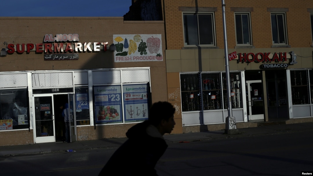 Seorang remaja putra mengendarai sepeda melintas di supermarket Al-Noor dan toko Hookah di Hamtramck, Michigan, 14 November 2016. (Foto: Reuters)